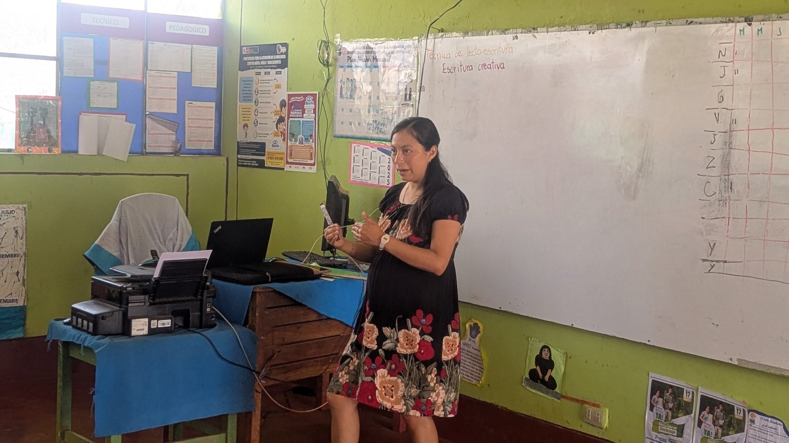 Miriam en un taller de alfabetización explicando técnica de lecto-escritura en una pizarra